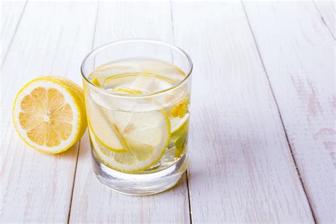 Pohár vody s citrónom a bylinkový čaj