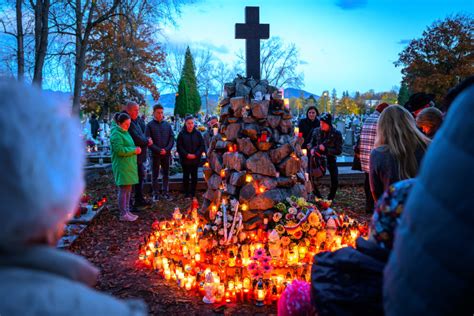 Rodina zdobiaca hrob počas Sviatku Všetkých svätých