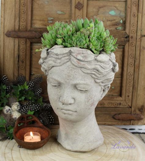 Kvetináč v tvare hlavy s písacími potrebami