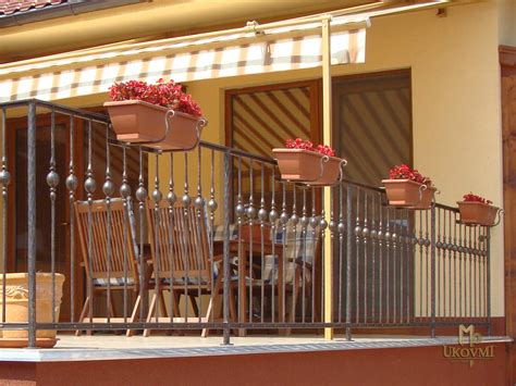 Kvetináče zavesené na balkónovom zábradlí pomocou držiakov