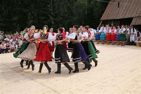 Ľudia tancujúci ľudový tanec v tradičných krojoch